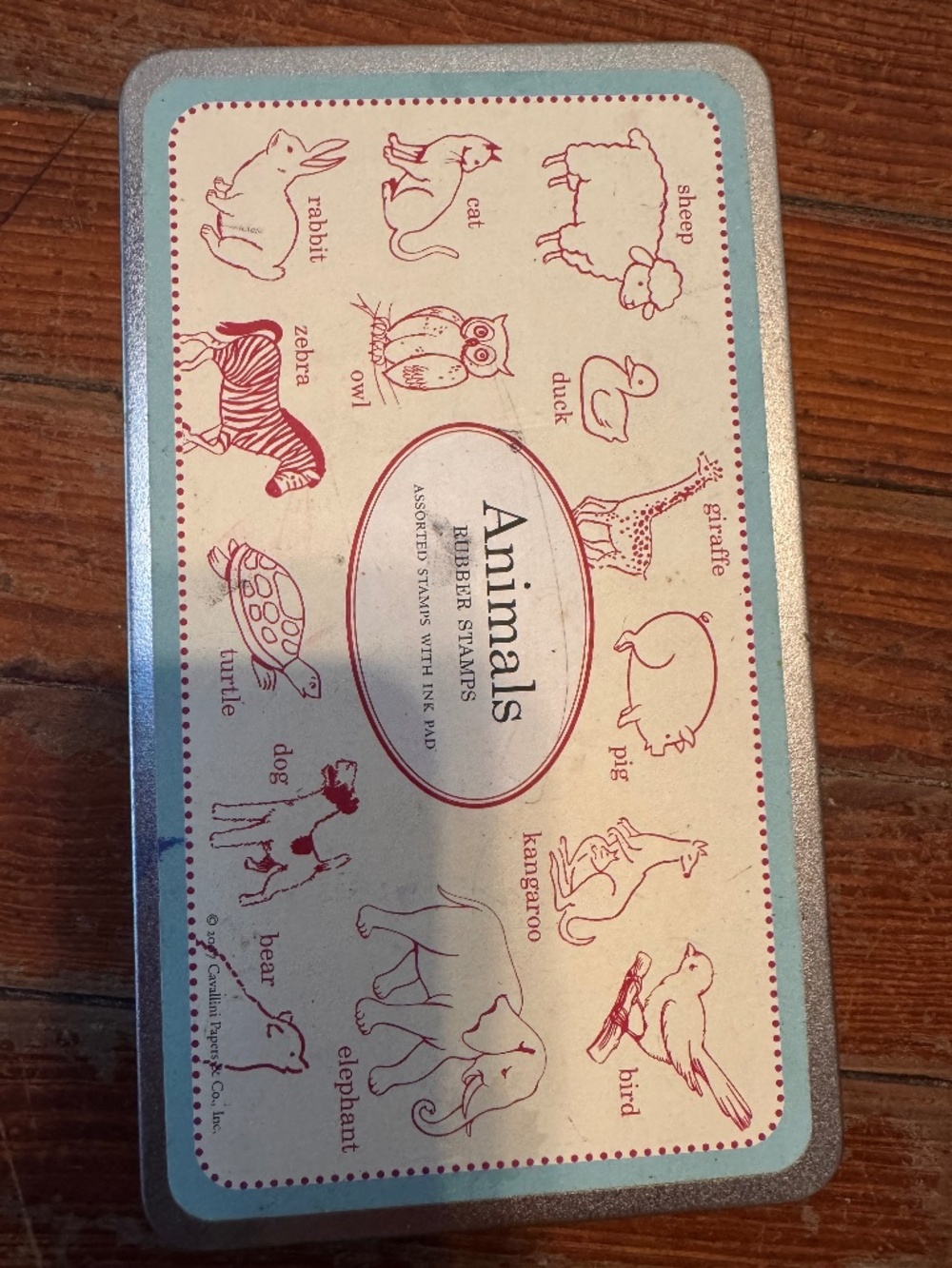 This is a vintage-style tin of animal-themed rubber stamps produced by Cavallini